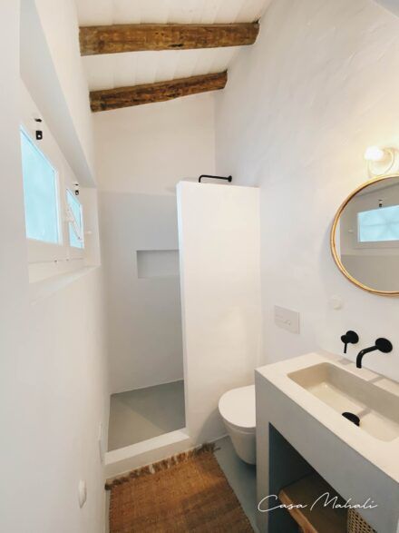 a bathroom with a sink, toilet and mirror