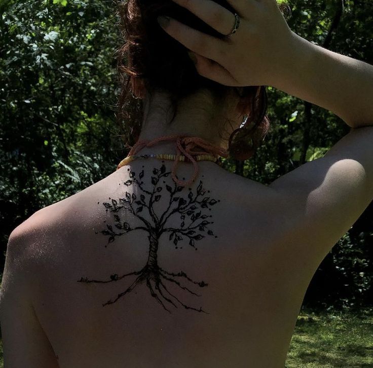 a woman with a tree tattoo on her back