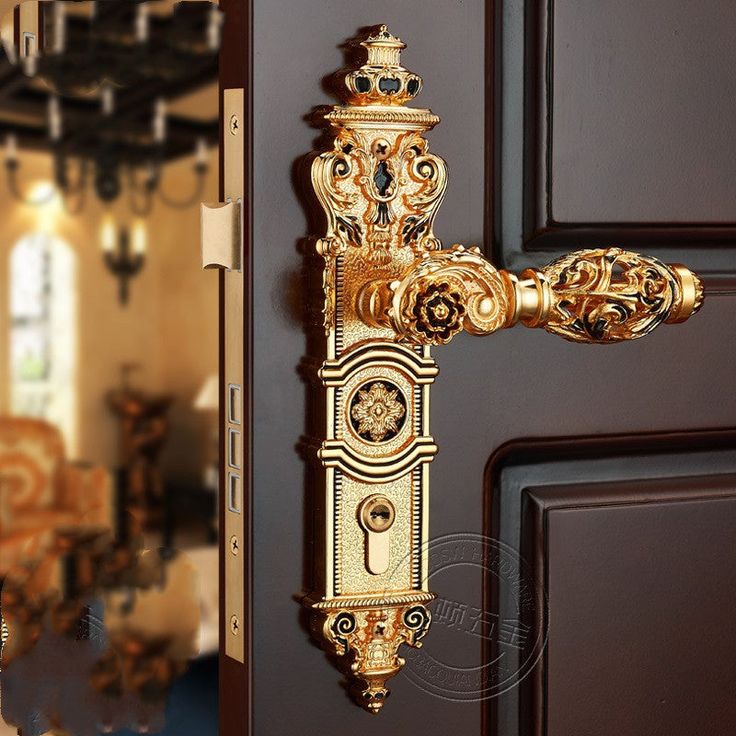 an ornate golden door handle on a brown door