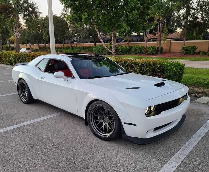 a white sports car parked in a parking lot