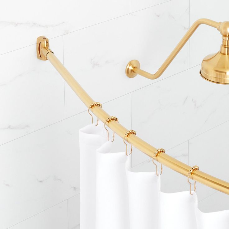 a shower curtain with gold hardware and white curtains