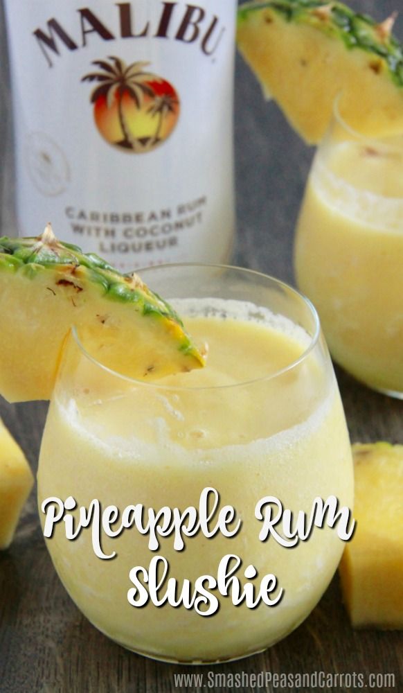 pineapple rum slushie is garnished with fresh pineapple and mint