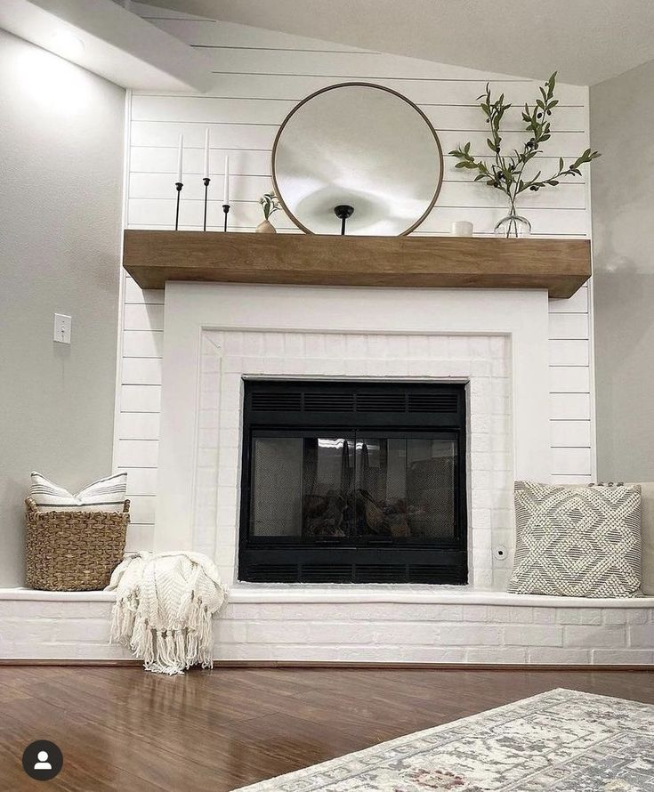 a living room with a fire place and white painted brick fireplace mantel above it