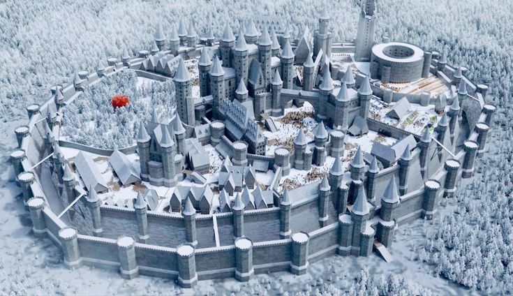 an aerial view of a castle in the middle of snow covered trees with a red balloon flying over it