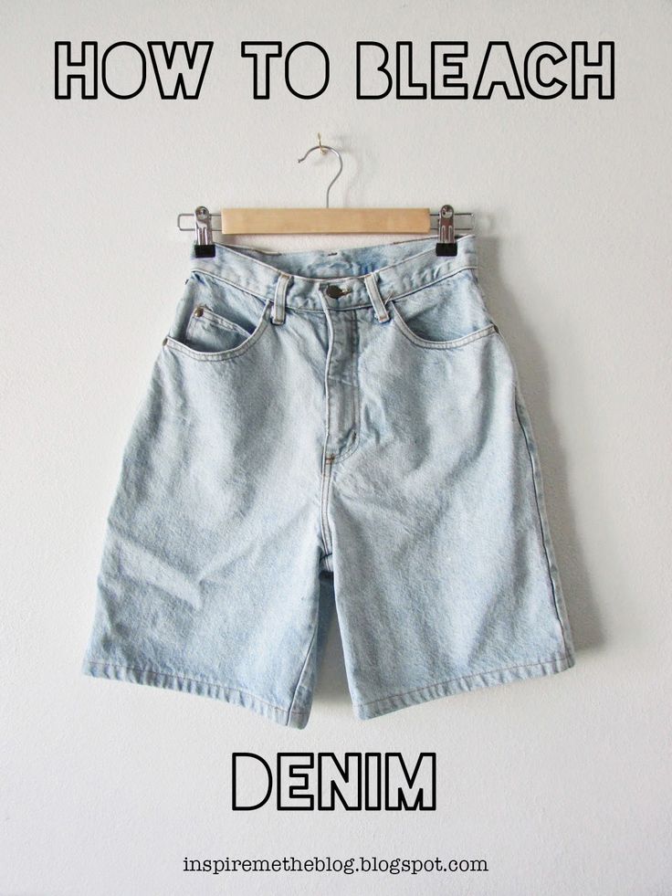 a pair of light blue denim shorts hanging on a white wall