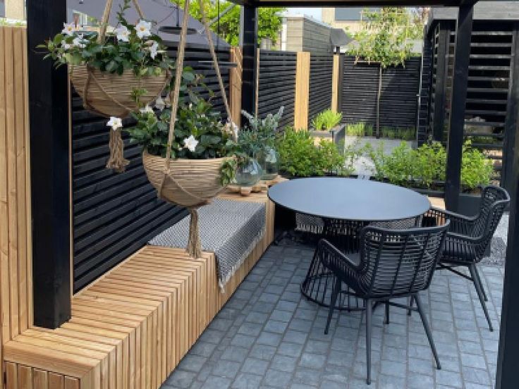 an outdoor seating area with potted plants and hanging planters