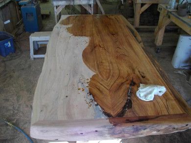 a wooden table in a workshop with some tools on it and one piece of wood sticking out of the top