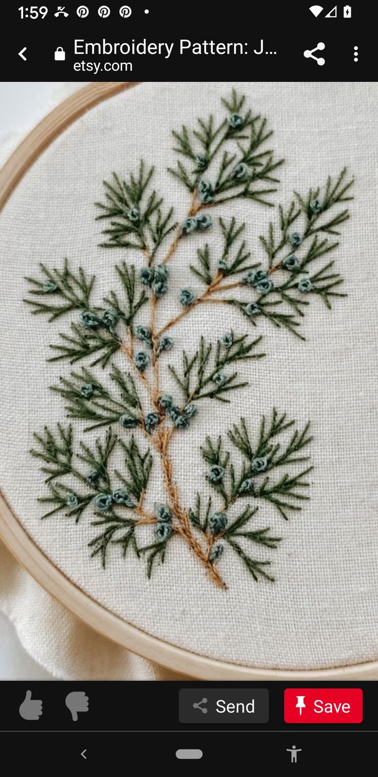 a close up of a cross stitch pattern with pine needles and berries on the needle