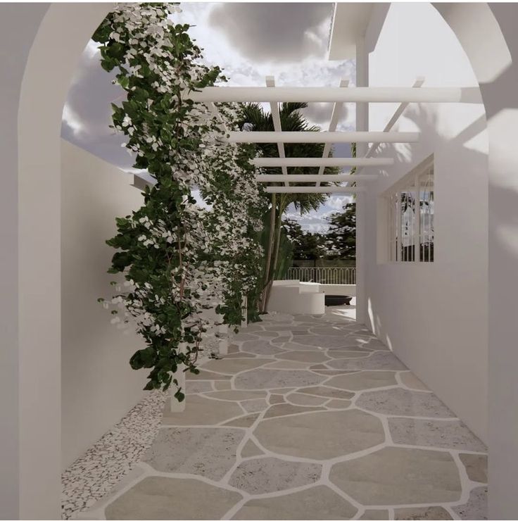 an archway with white flowers and vines on the outside, leading to a patio area