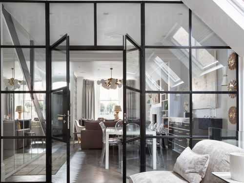 a living room filled with furniture and lots of glass doors leading to an open floor plan