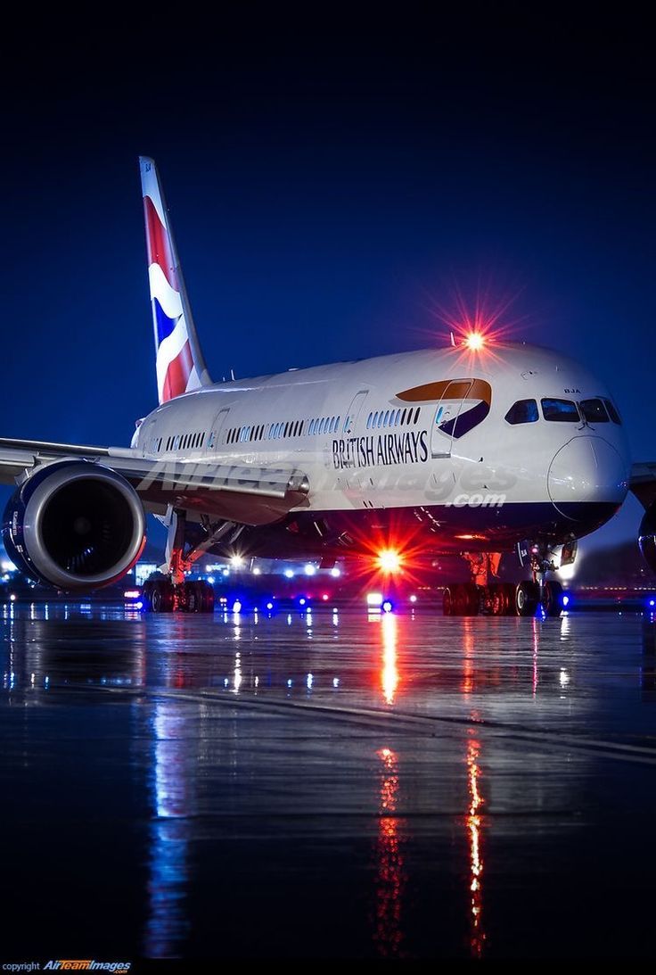 an airplane is parked on the runway at night