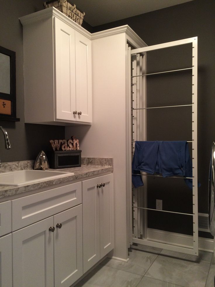 a bathroom with white cabinets and blue towels hanging on the rack above the sink area