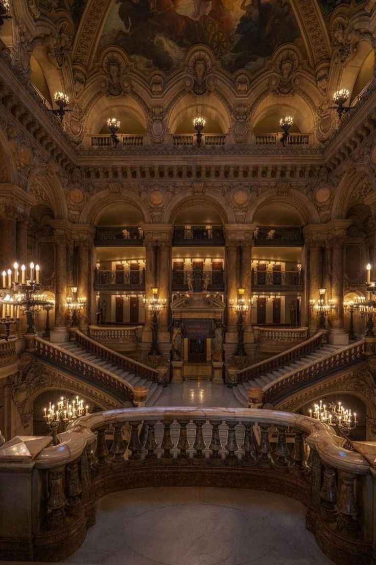 an ornate building with many chandeliers and paintings on the walls, along with marble stairs