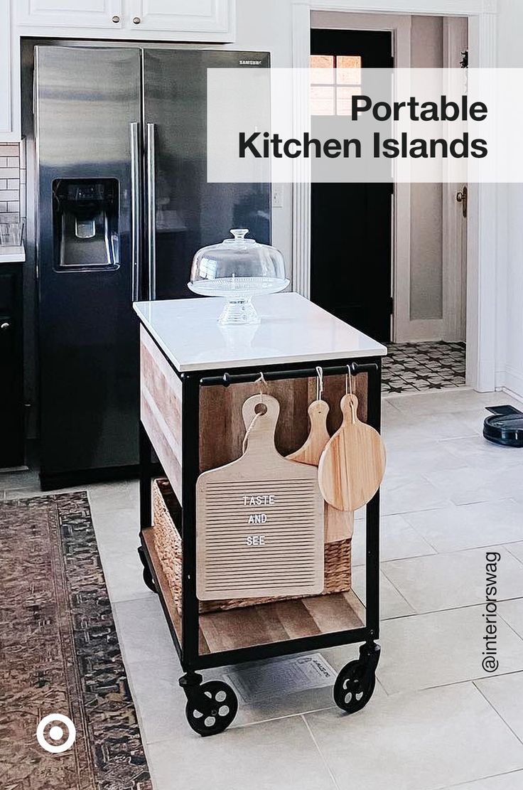 a kitchen island with wooden cutting boards on it in front of a black refrigerator and white cabinets