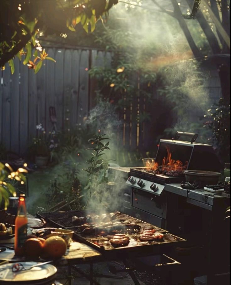 an outdoor grill with food cooking on it in the evening sun, surrounded by trees and bushes