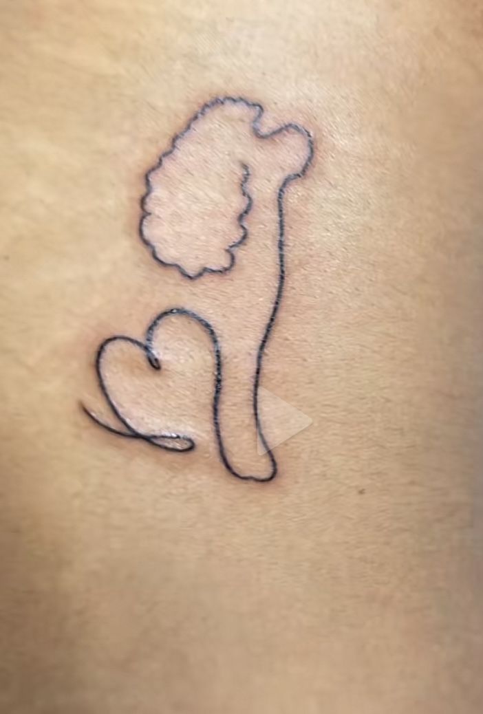 a woman's stomach with a tattoo on it that has a silhouette of a dog and a heart