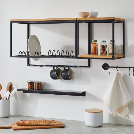 a kitchen counter with pots and pans on the shelves above it, along with utensils