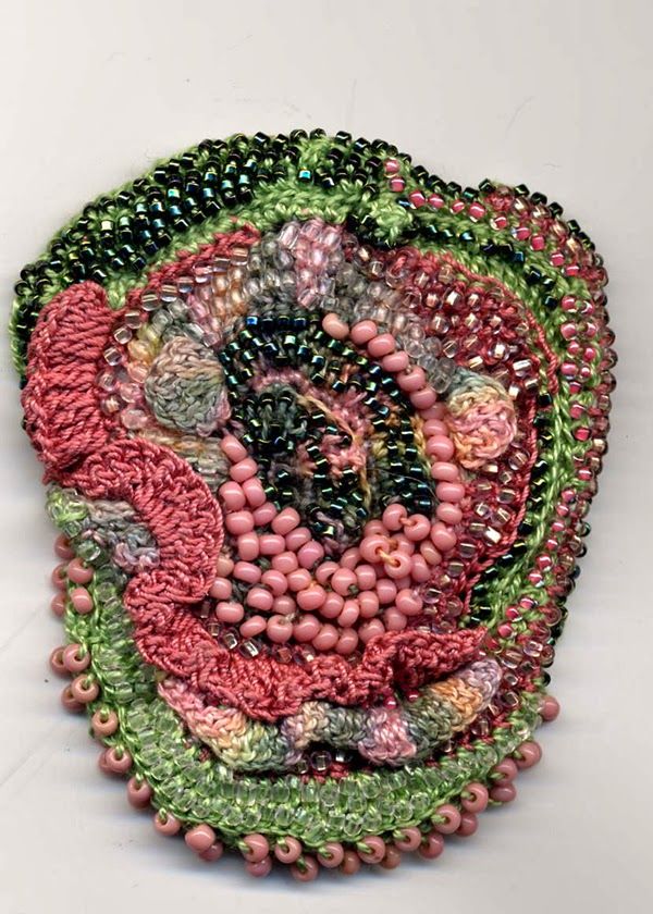 a circular piece of art made out of beads and other items on a white surface