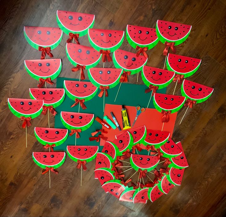 a bunch of watermelon shaped kites on a wooden floor