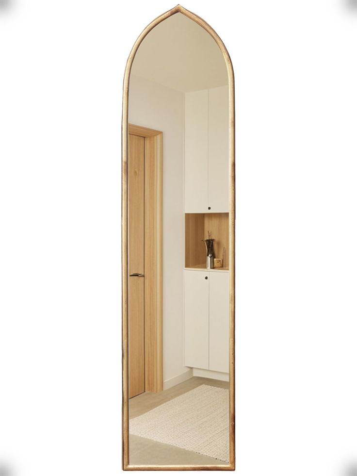 an arch shaped mirror in the middle of a room with white walls and beige carpet