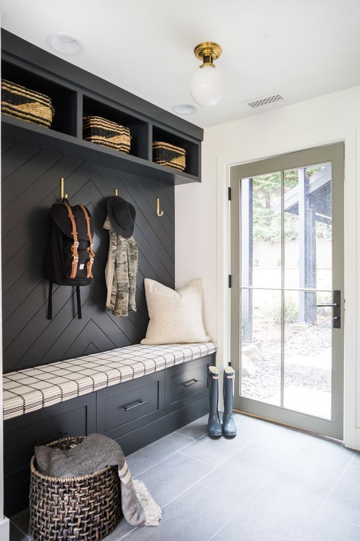 a black and white entryway with two coats hanging on the wall