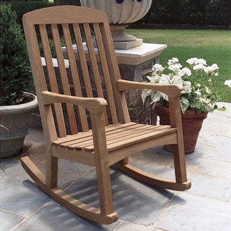 a wooden rocking chair sitting on top of a stone patio