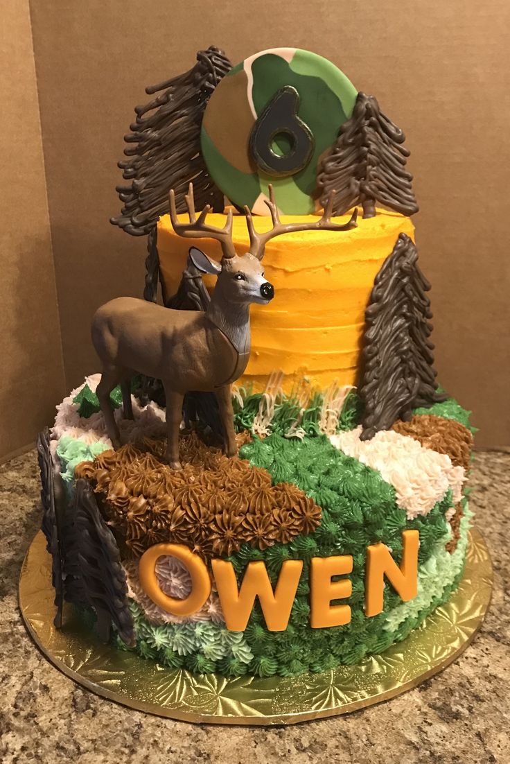 there is a cake decorated with deer and trees