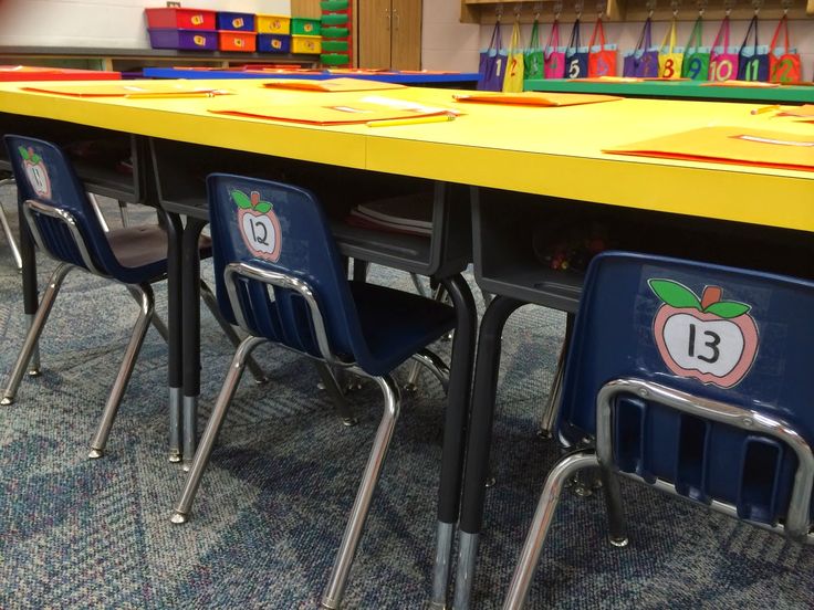 an empty classroom table with chairs and numbers on it