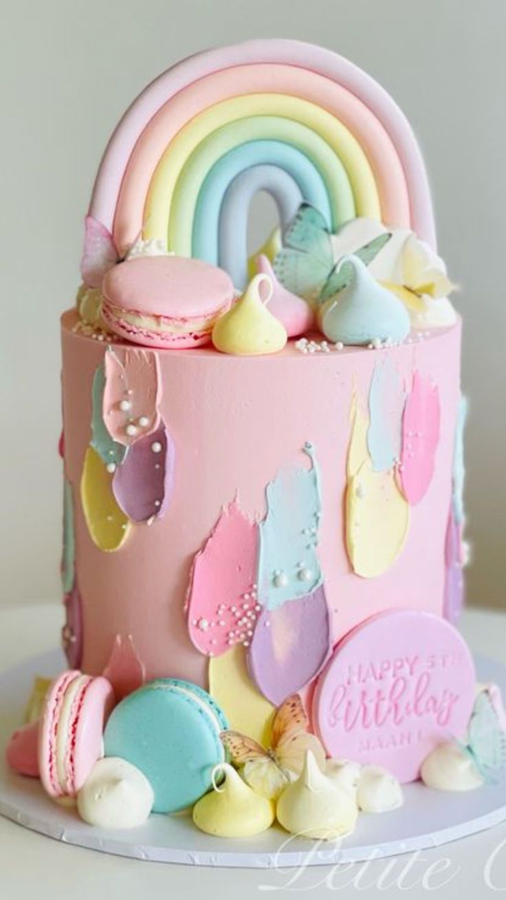 there is a cake decorated with pastel colors and rainbows on the top layer