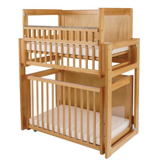 a wooden bunk bed with two white mattresses on the bottom and one above it