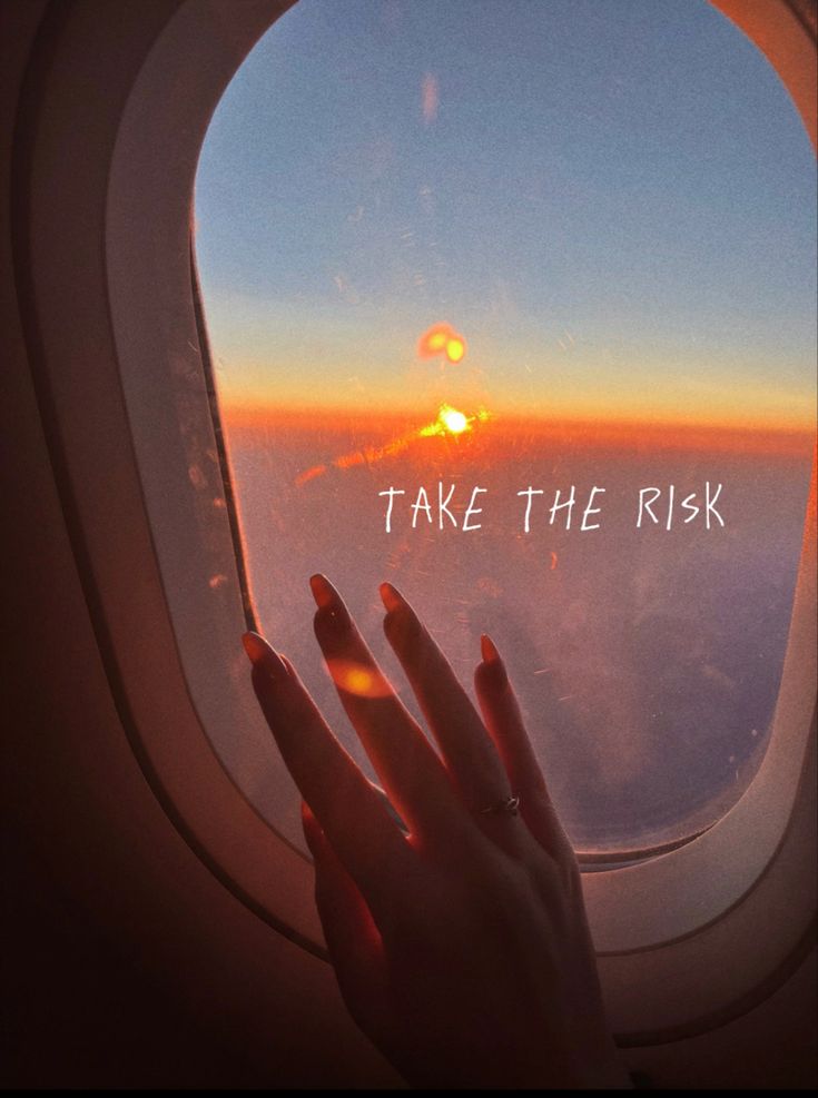 someone's hand on the edge of an airplane window that reads, take the risk