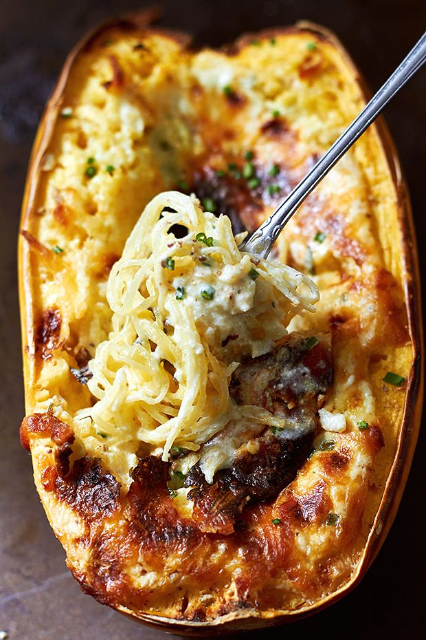 spaghetti and meat stuffed sweet potatoes in a baking dish with a fork sticking out of the top