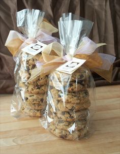 two bags filled with cookies sitting on top of a wooden table