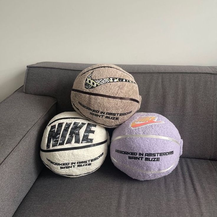 three balls sitting on top of a gray couch