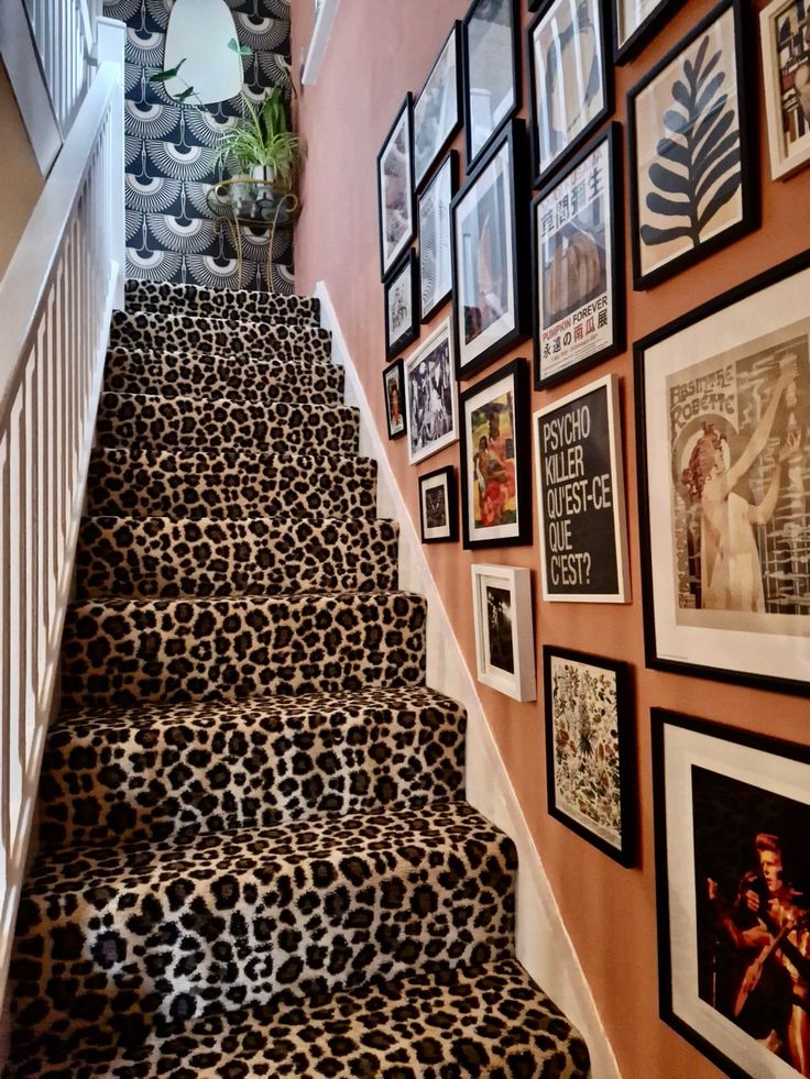 the stairs are decorated with pictures and frames