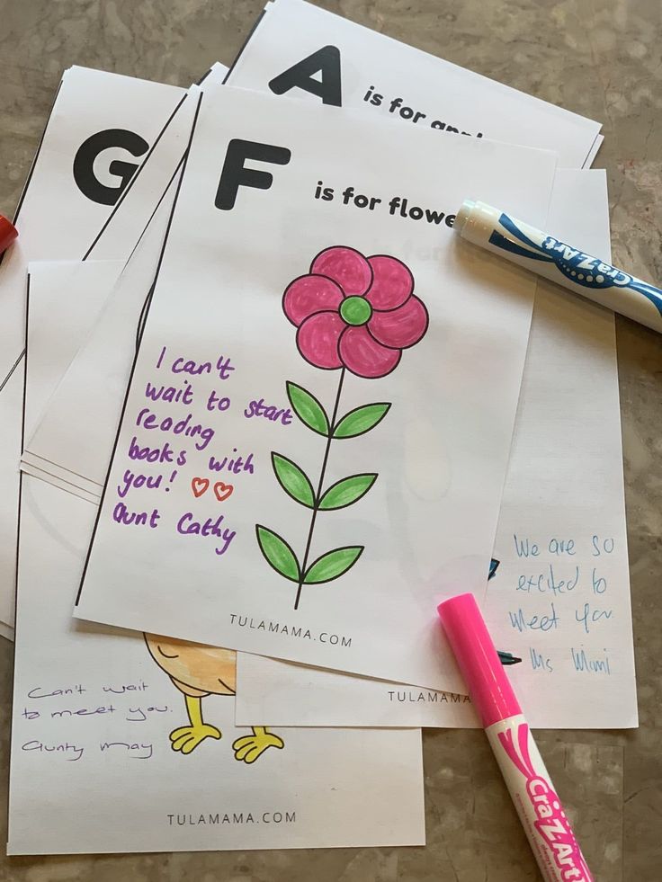 four children's coloring sheets with flowers and words on them next to a crayon marker