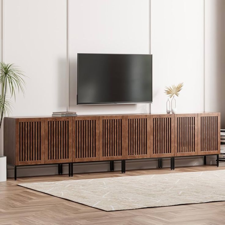 a large flat screen tv mounted to the side of a wooden entertainment center in a living room