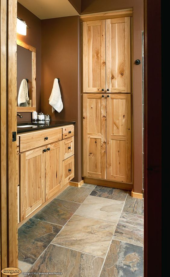 a bathroom with wooden cabinets and tile flooring