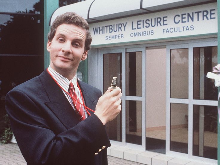 a man in a suit and tie holding a cell phone