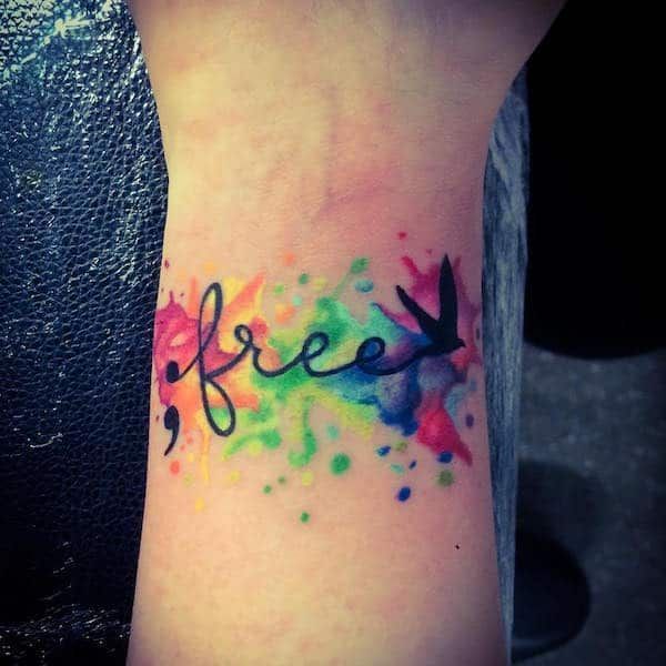 a tattoo with the word free painted on it's arm and colorful ink splatters