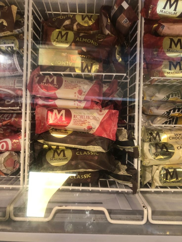 an open refrigerator filled with lots of different types of food and snacks in it's display case