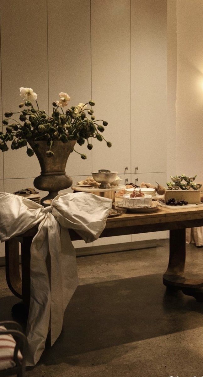 the table is set up with flowers and desserts for two people to eat together