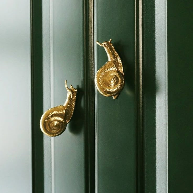 two gold seahorses are attached to the green doors