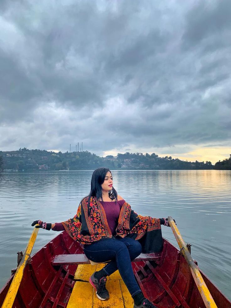 a woman is sitting in a boat on the water