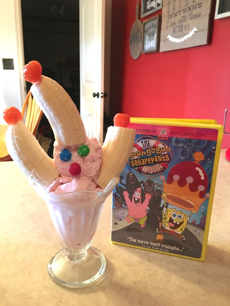 an ice cream sundae topped with candy and banana peels in a glass vase