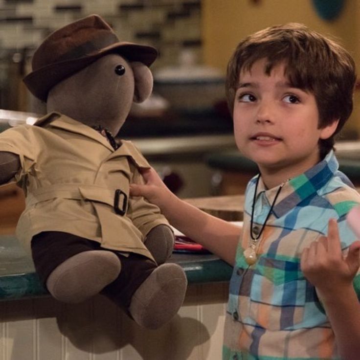 a young boy holding onto a stuffed animal