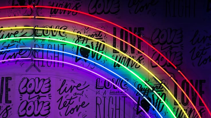 a rainbow lit up in the dark with writing all over it