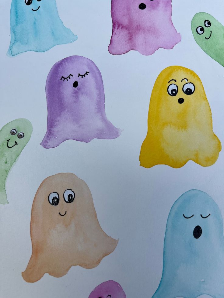 watercolor ghost faces on white paper with blue eyes and one face drawn in different colors