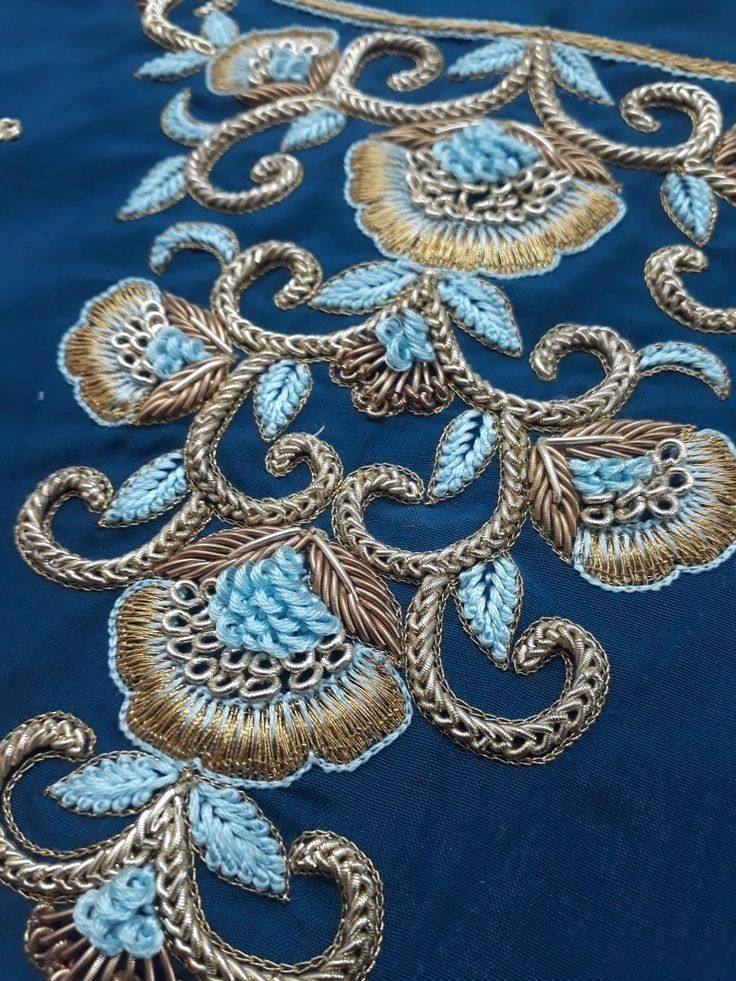 blue and gold embroidered fabric with flowers on it