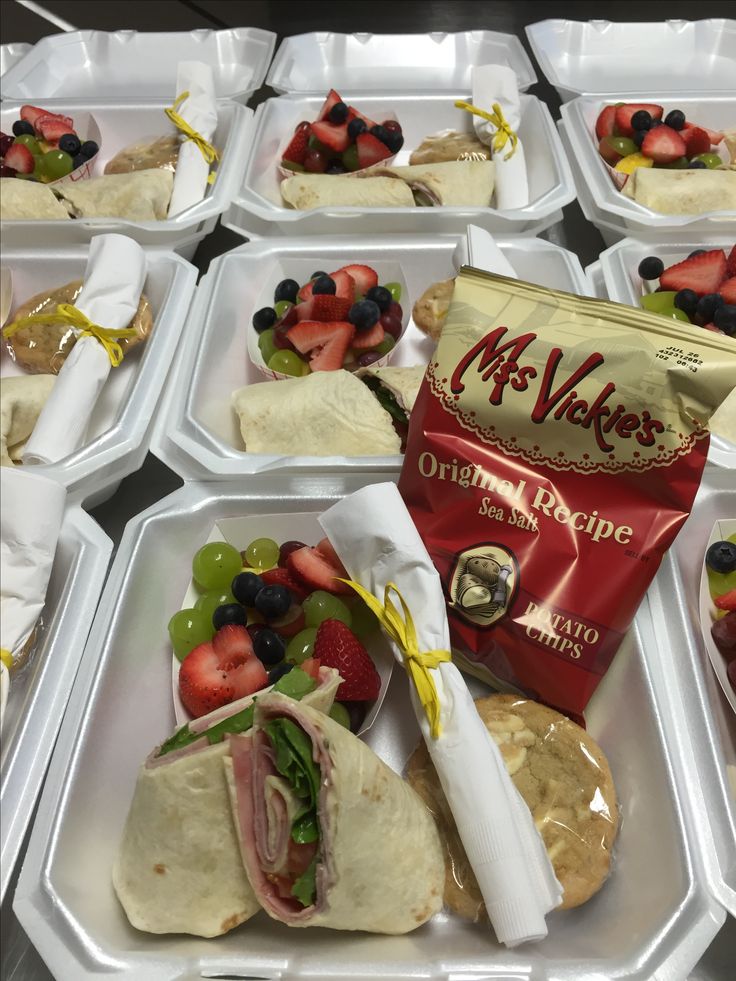 several trays filled with sandwiches and fruit on top of eachother's wrappers